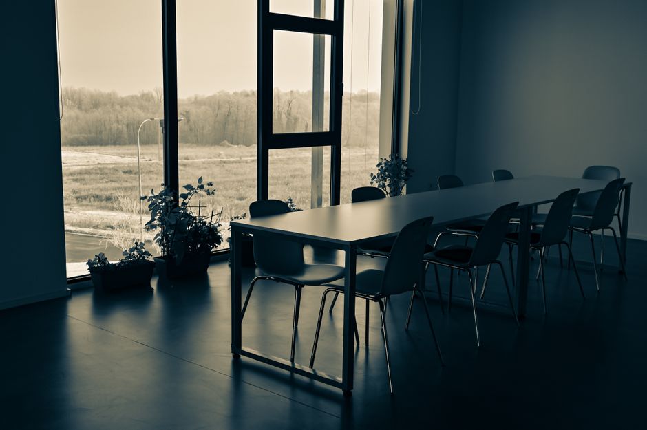 Empty meeting room with a long table and windows