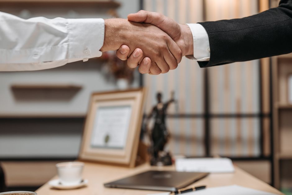 Two people shaking hands in a law office