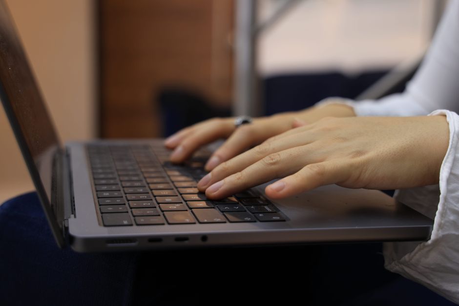 Hands typing on a laptop keyboard