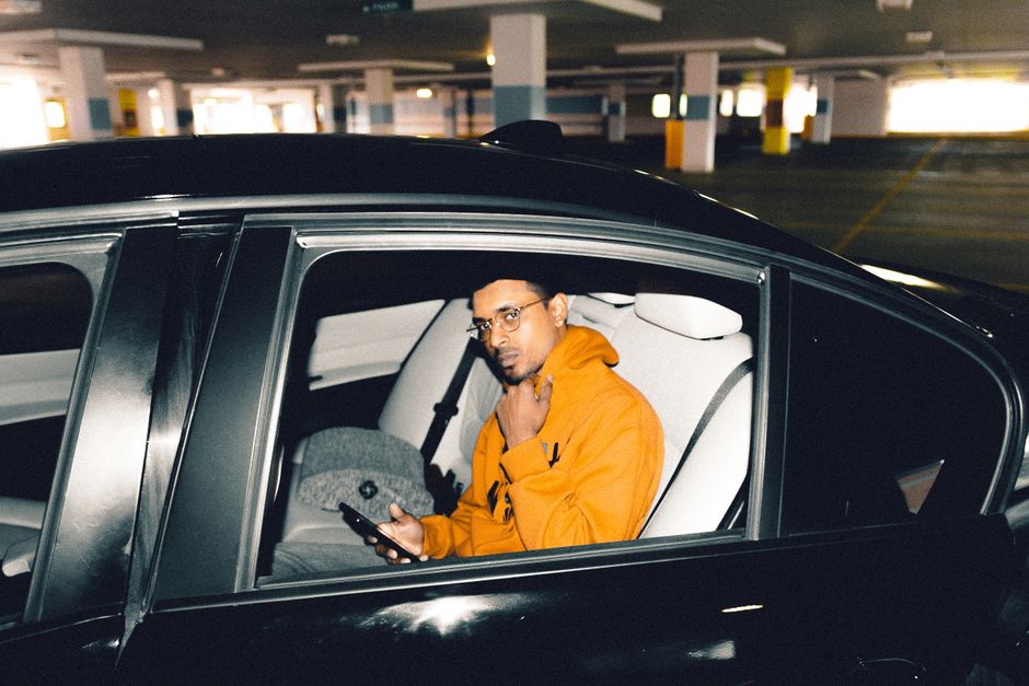 Person holding a phone in the back of a car